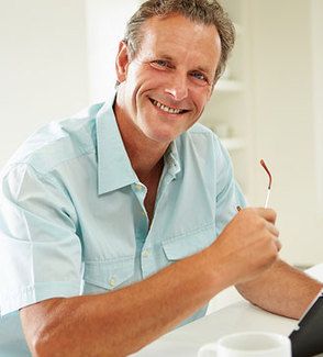 Smiling man holding glasses